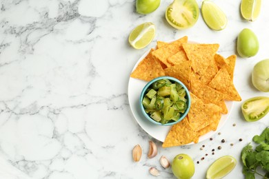 Photo of Delicious salsa with nachos on white marble table, flat lay. Space for text