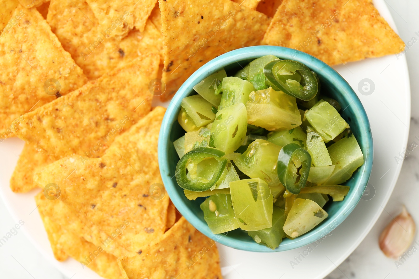 Photo of Delicious salsa with nachos on white table, top view