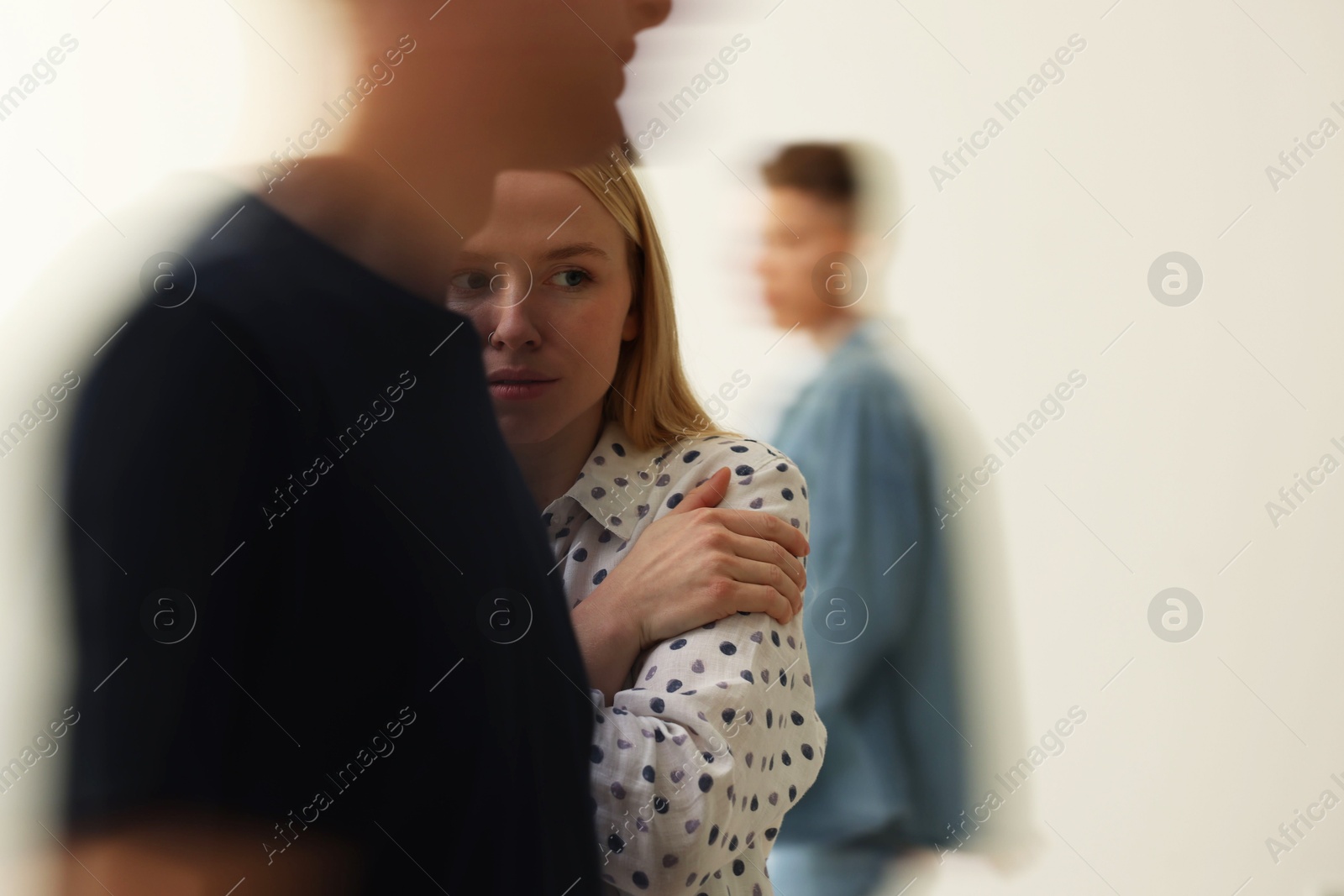 Photo of Young woman feeling uncomfortable among people indoors