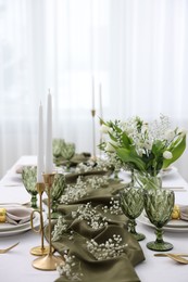 Color accent table setting with glasses, flowers and olive napkins