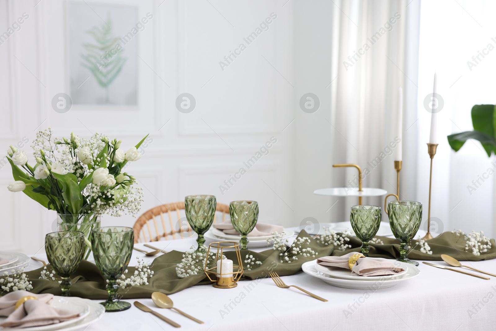 Photo of Color accent table setting with glasses, flowers and olive napkins