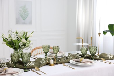 Color accent table setting with glasses, flowers and olive napkins