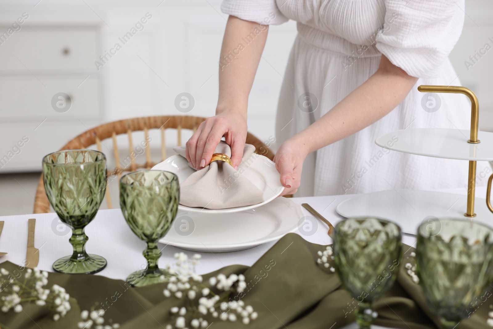 Photo of Young woman setting table for dinner at home, closeup