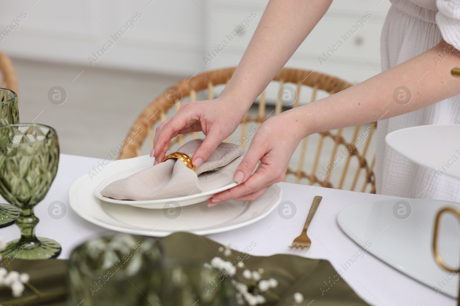 Photo of Young woman setting table for dinner at home, closeup