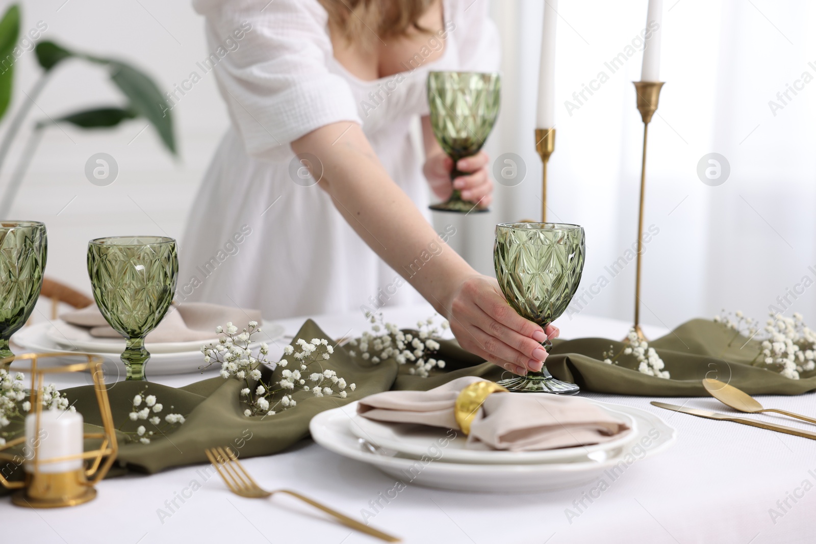 Photo of Young woman setting table for dinner at home, closeup