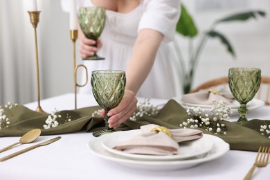 Photo of Young woman setting table for dinner at home, closeup