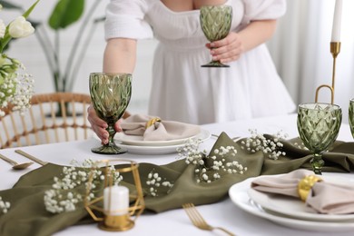 Photo of Young woman setting table for dinner at home, closeup