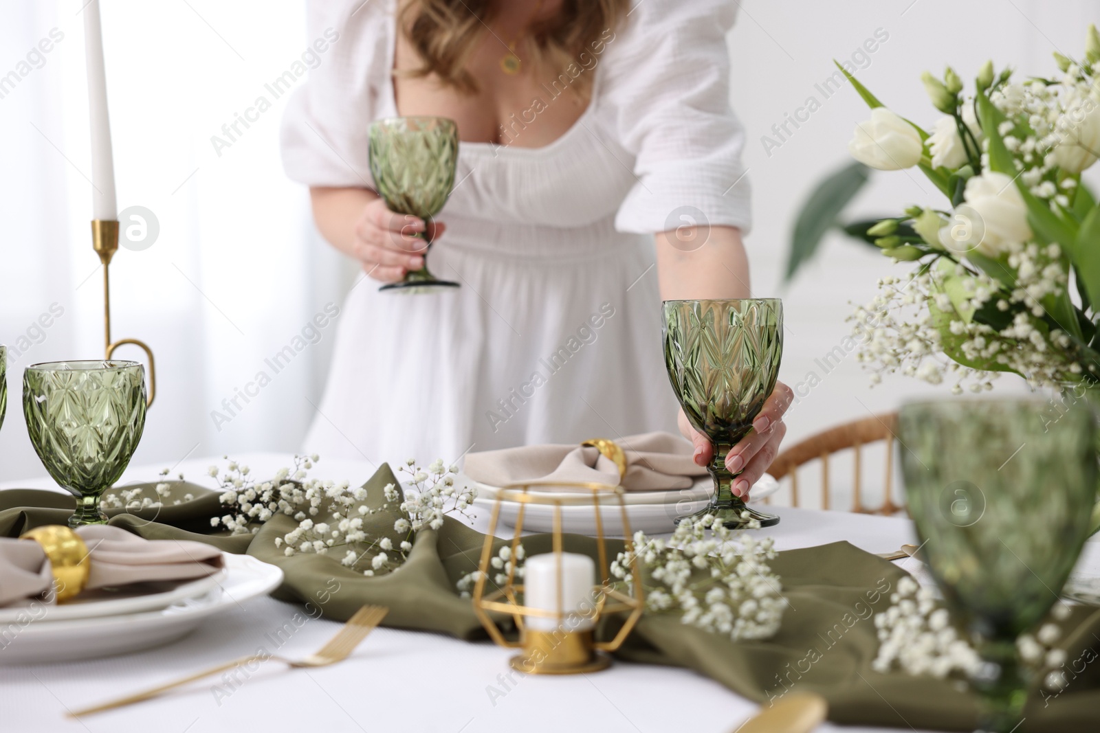 Photo of Young woman setting table for dinner at home, closeup