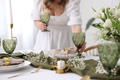 Photo of Young woman setting table for dinner at home, closeup