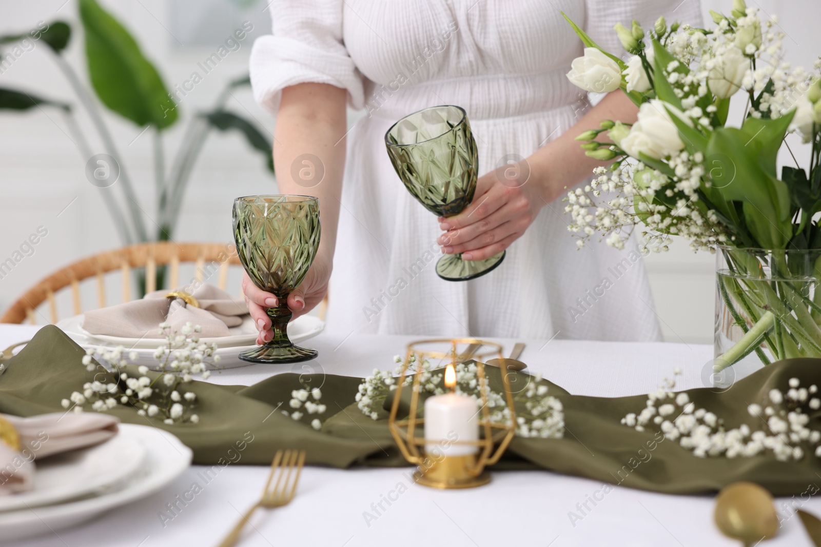 Photo of Young woman setting table for dinner at home, closeup