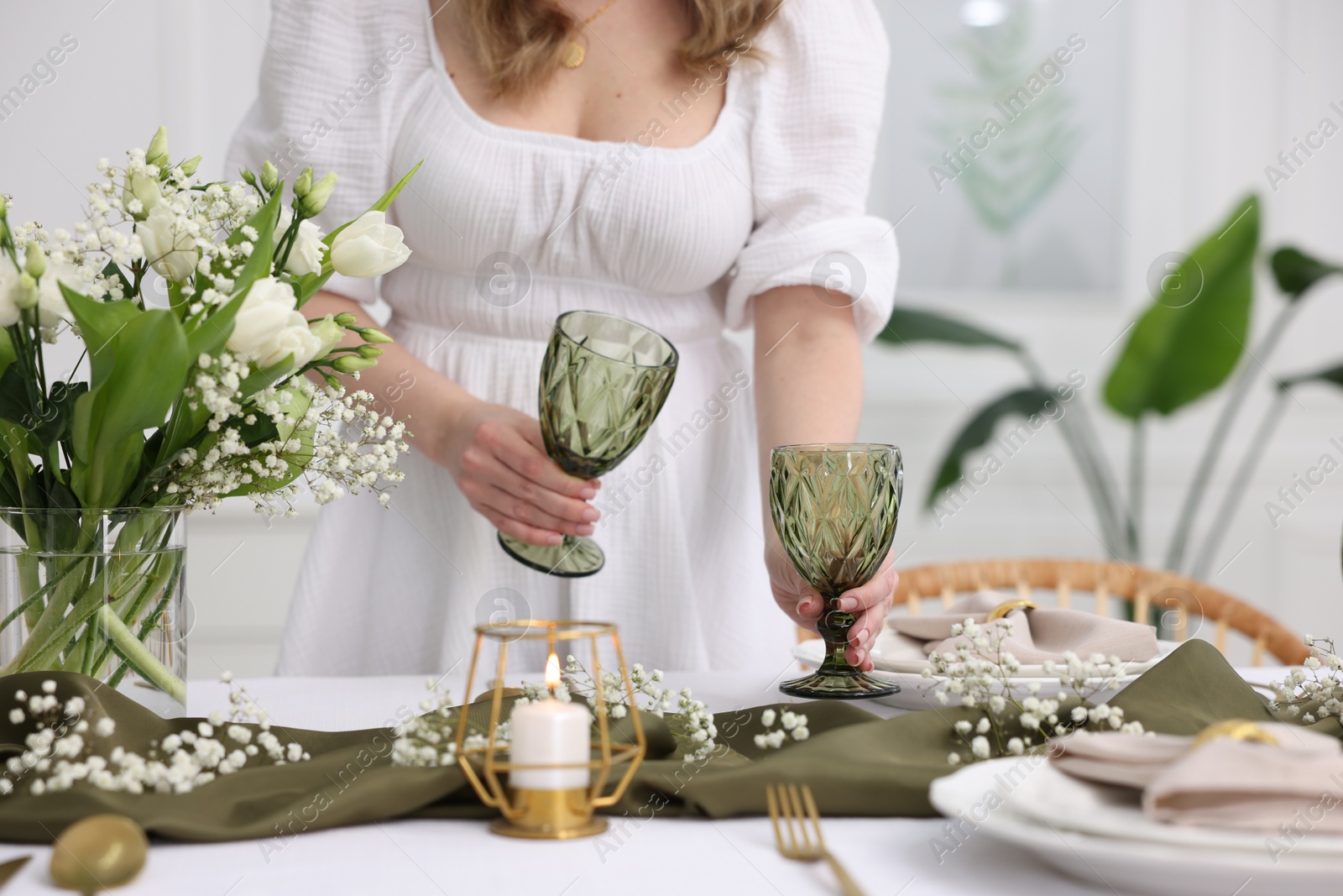 Photo of Young woman setting table for dinner at home, closeup