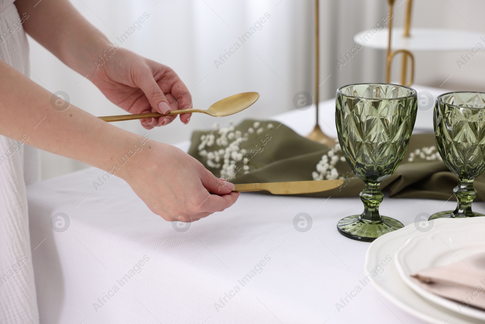 Photo of Young woman setting table for dinner at home, closeup