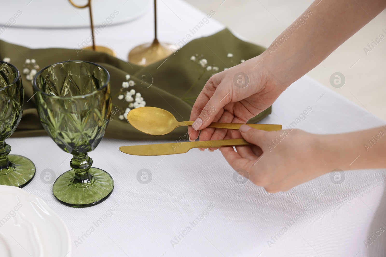 Photo of Young woman setting table for dinner at home, closeup