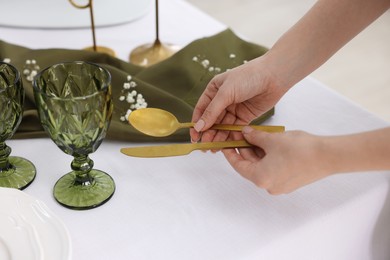 Photo of Young woman setting table for dinner at home, closeup