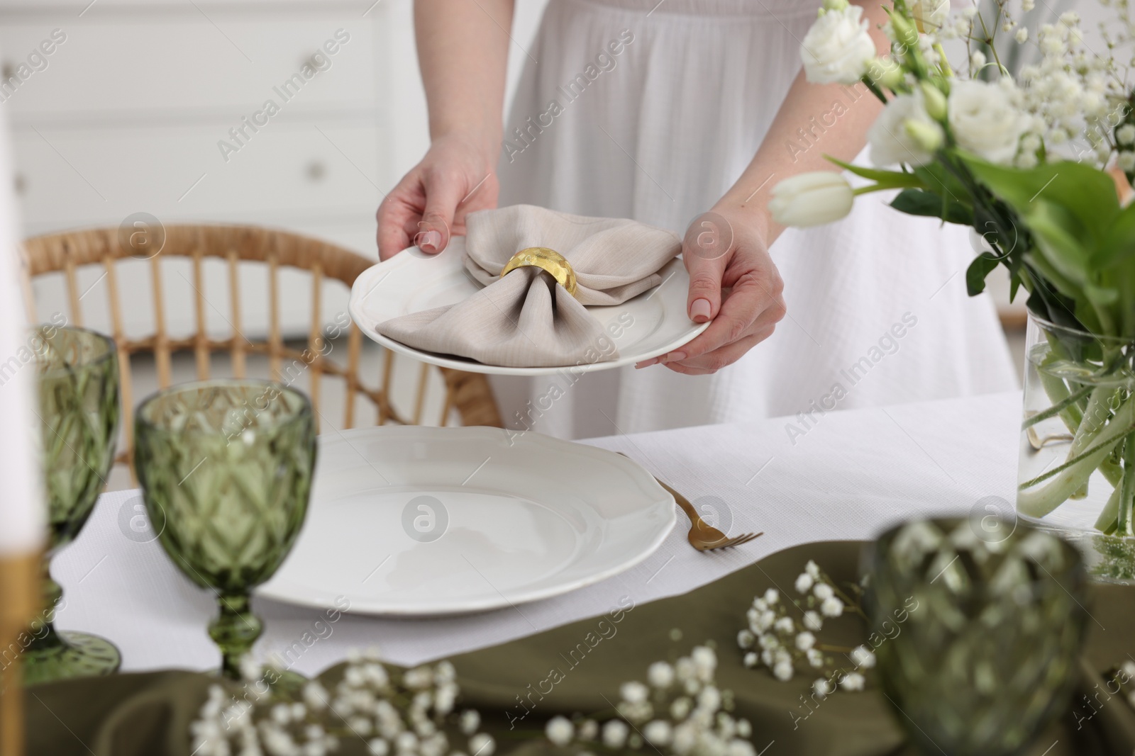 Photo of Young woman setting table for dinner at home, closeup