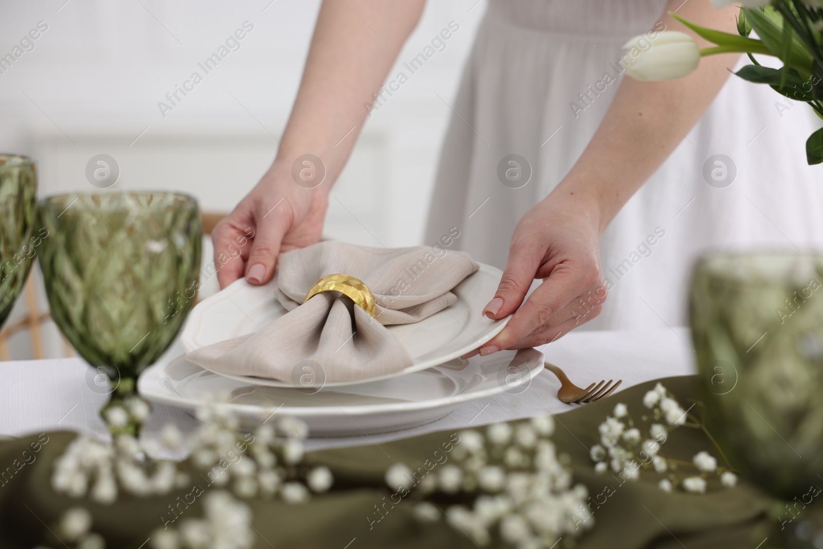 Photo of Young woman setting table for dinner at home, closeup