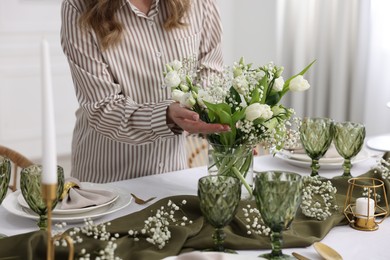 Young woman setting table for dinner at home, closeup