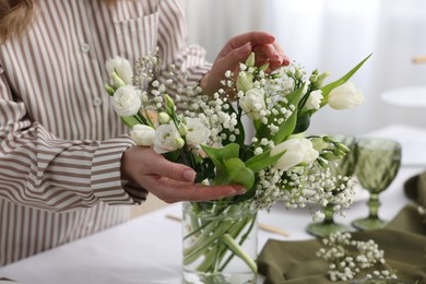 Young woman setting table for dinner at home, closeup