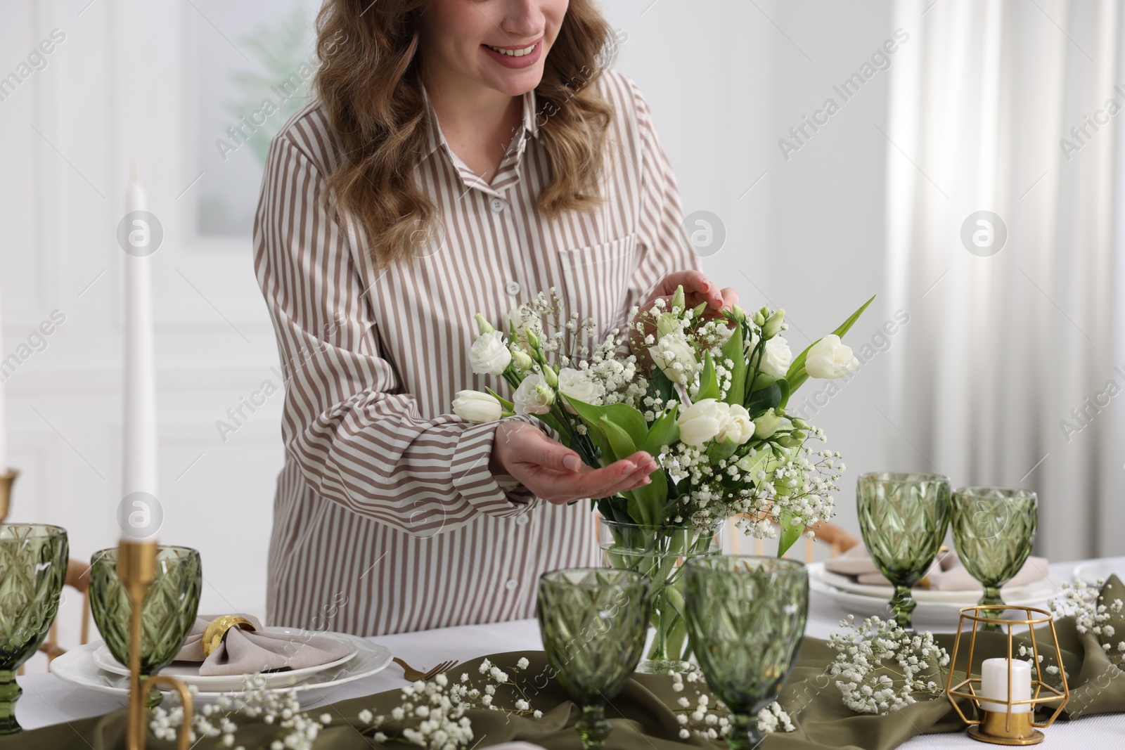 Photo of Young woman setting table for dinner at home, closeup