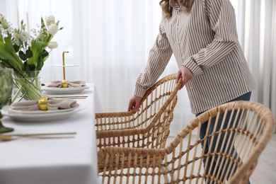 Photo of Young woman setting table for dinner at home, closeup