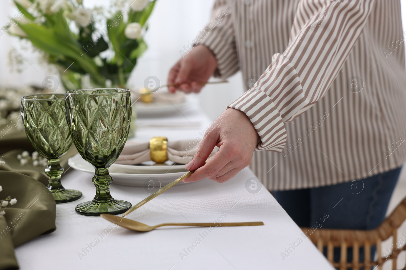 Photo of Young woman setting table for dinner at home, closeup