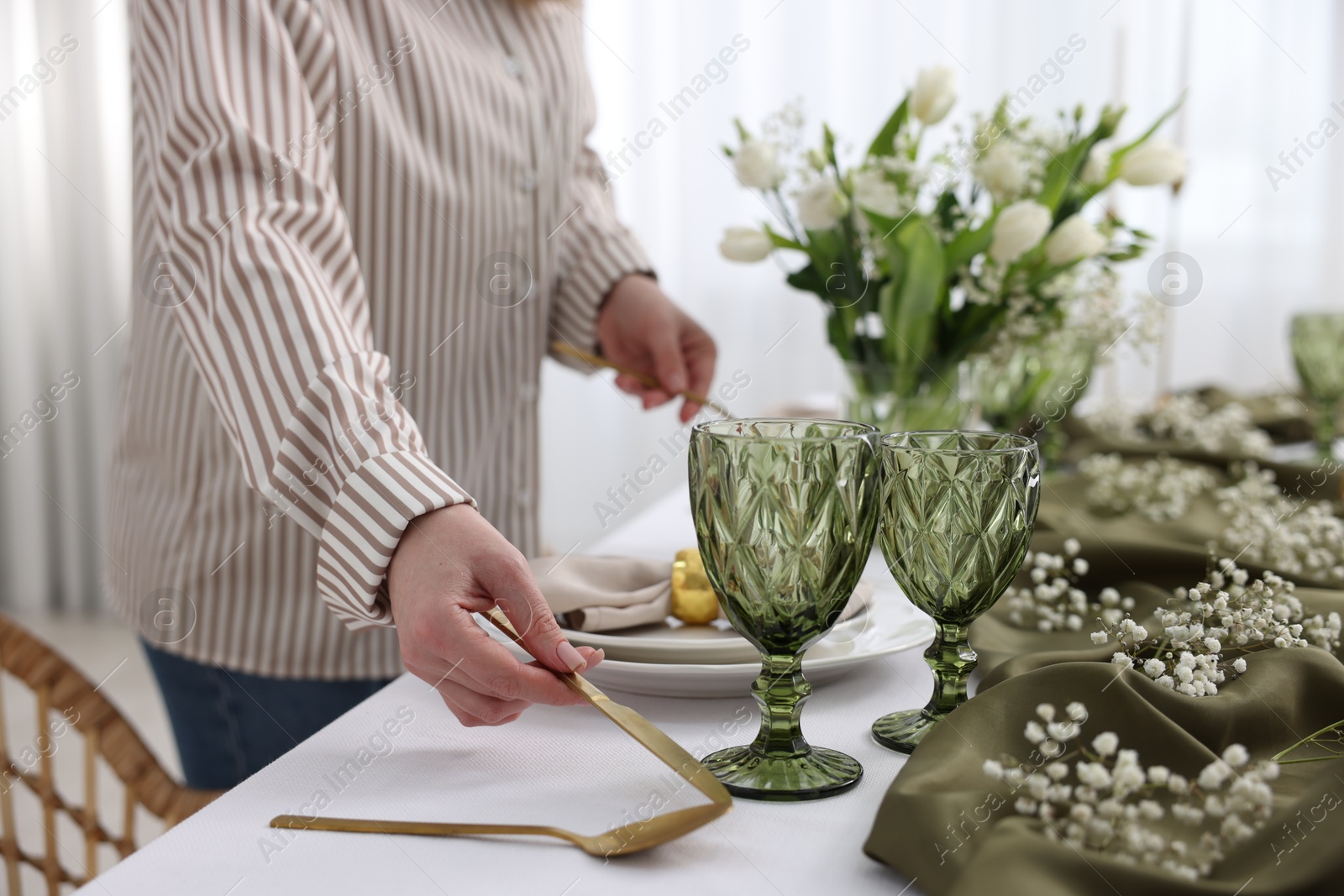 Photo of Young woman setting table for dinner at home, closeup