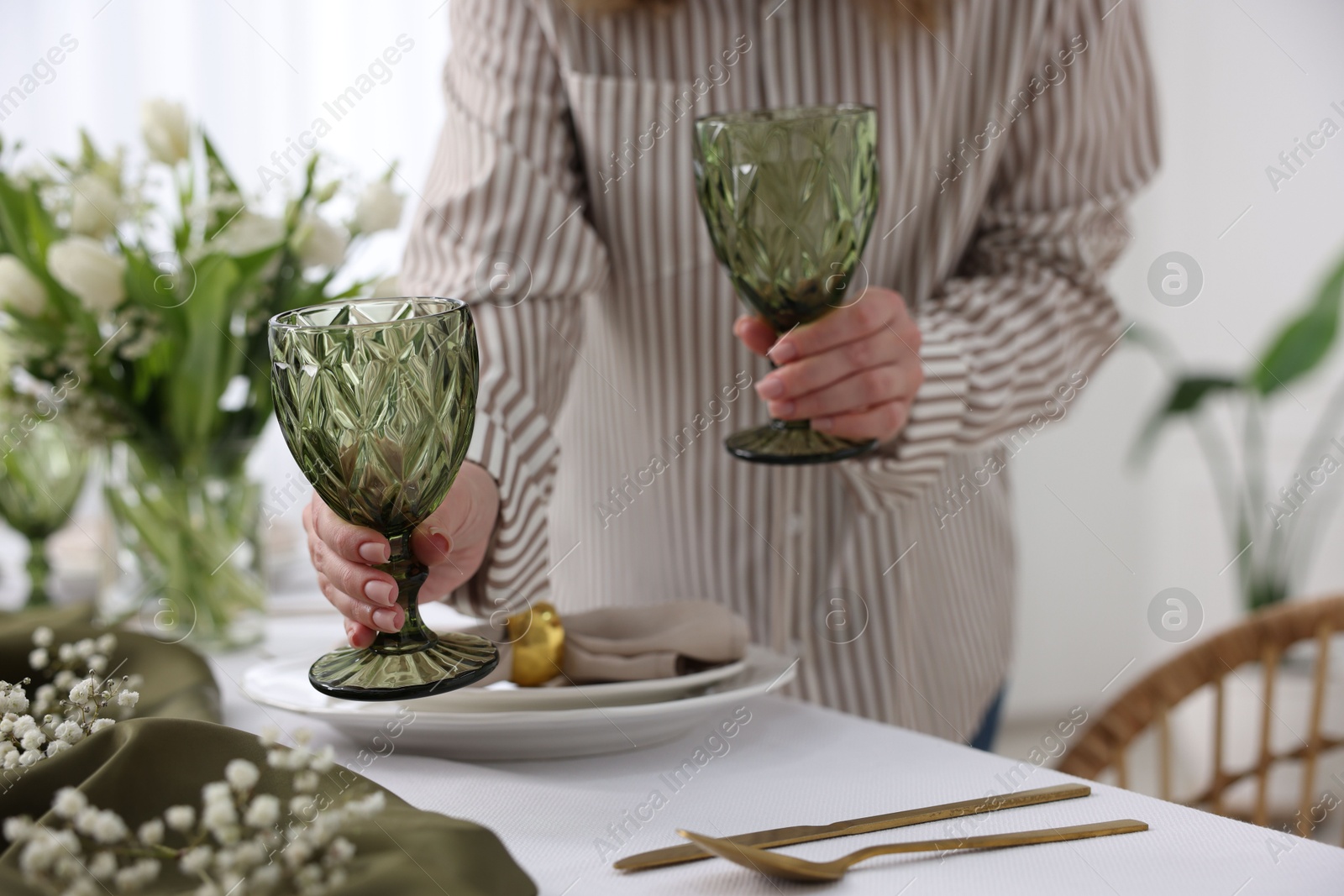 Photo of Young woman setting table for dinner at home, closeup