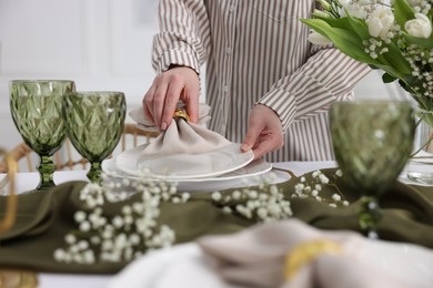 Photo of Young woman setting table for dinner at home, closeup