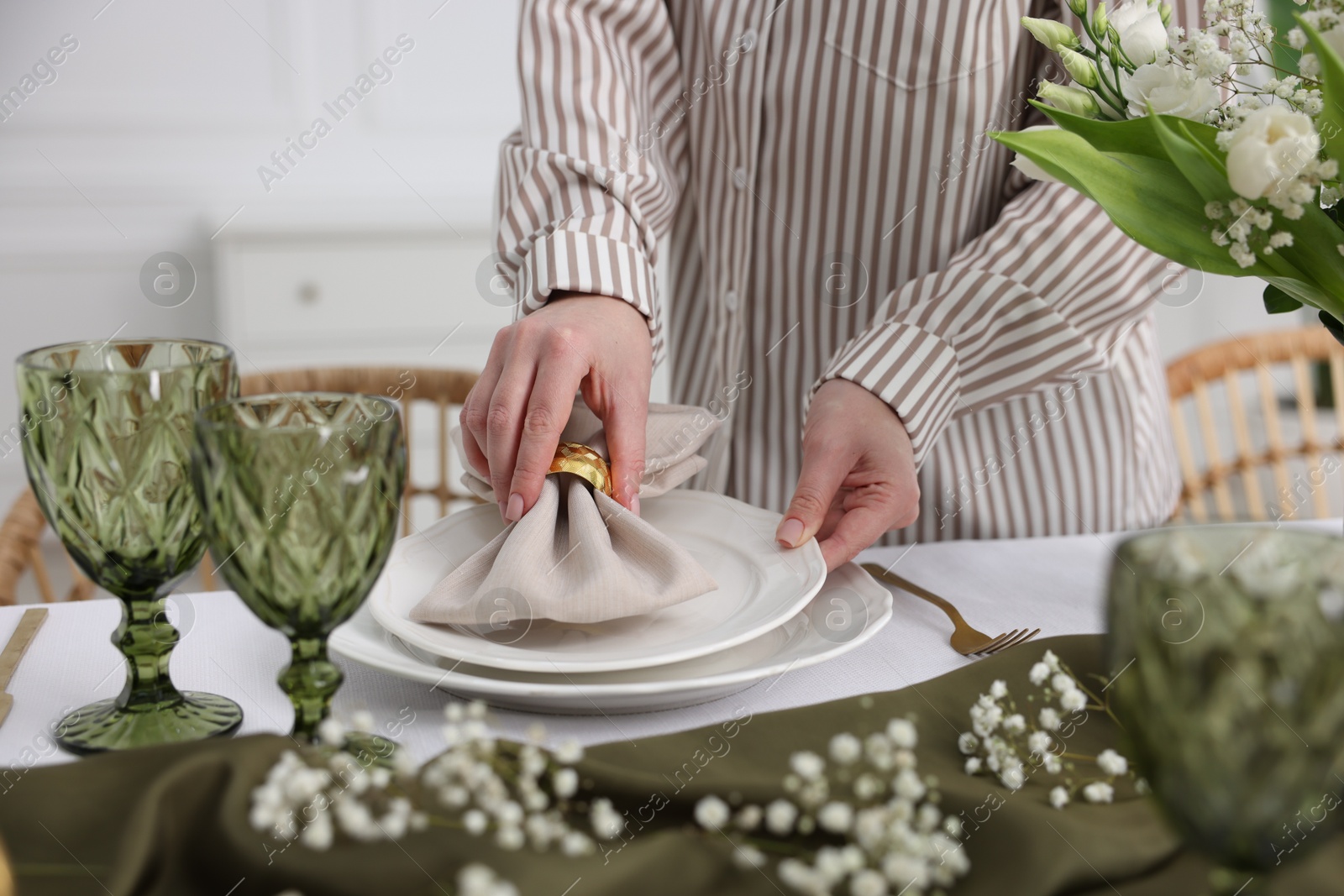 Photo of Young woman setting table for dinner at home, closeup