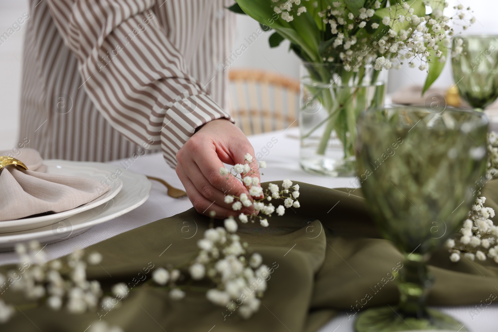 Photo of Young woman setting table for dinner at home, closeup