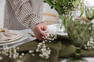 Young woman setting table for dinner at home, closeup