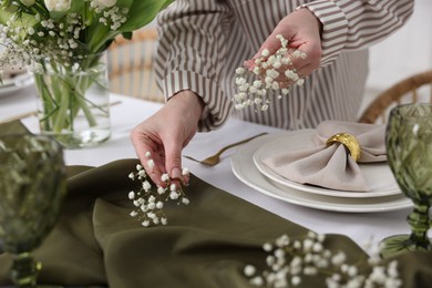 Young woman setting table for dinner at home, closeup