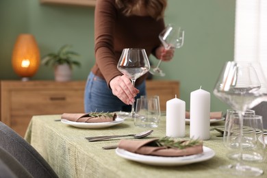 Photo of Young woman setting table for dinner at home, closeup