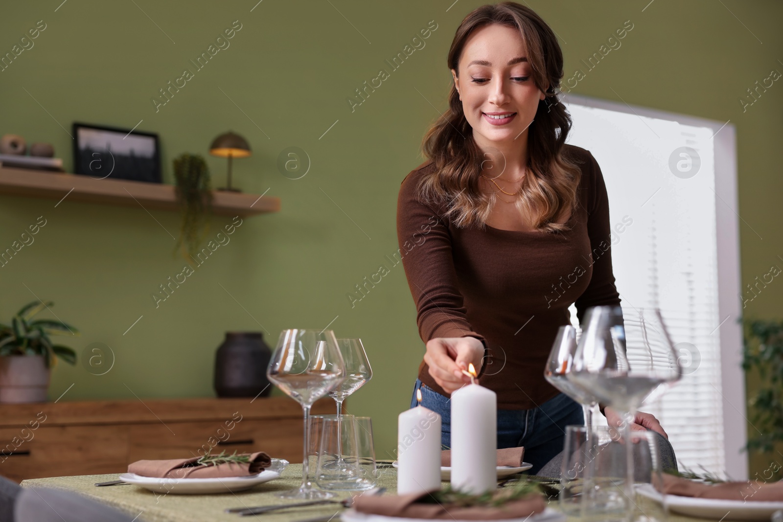 Photo of Happy young woman setting table for dinner at home