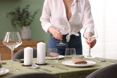 Photo of Young woman setting table for dinner at home, closeup