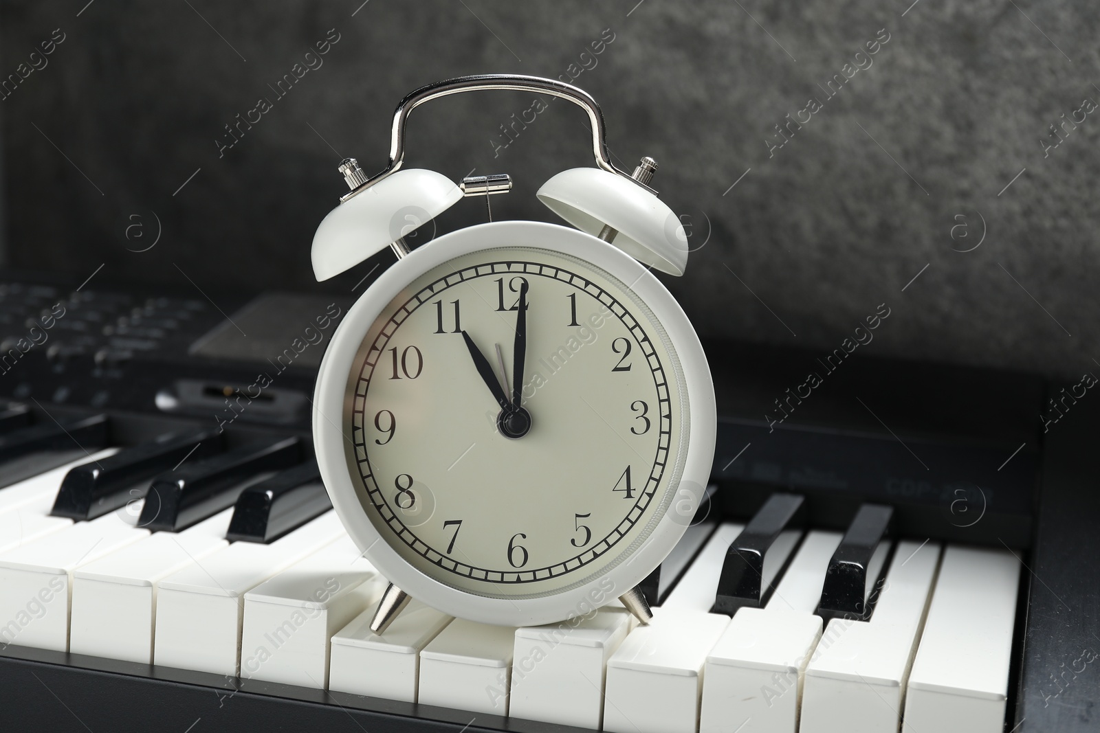 Photo of Alarm clock and electric piano on black table