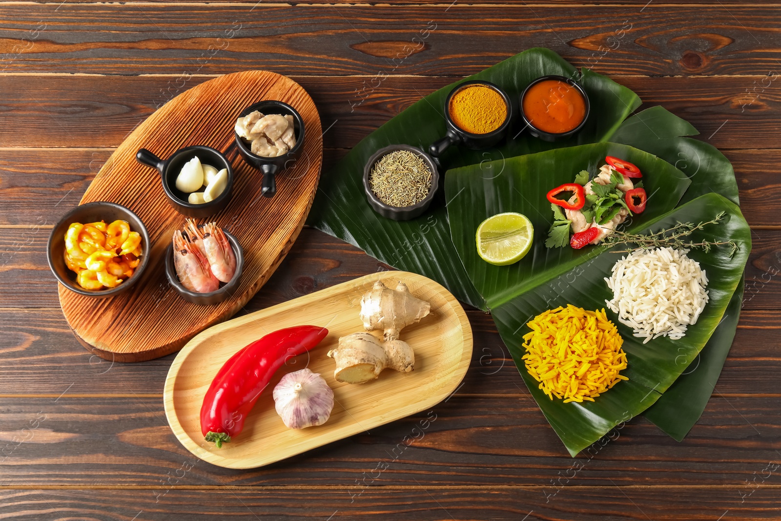 Photo of Flat lay composition with cut banana leaves, different food, spices and sauce on wooden table