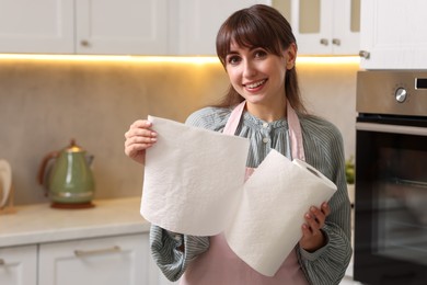 Smiling woman using paper towels in kitchen