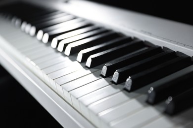 Photo of Synthesizer on black background, closeup. Electronic musical instrument