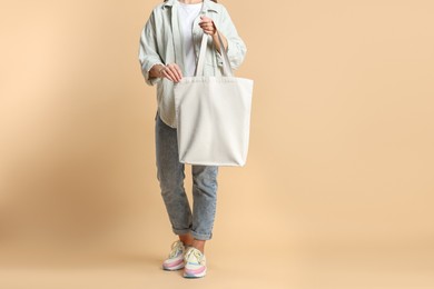 Photo of Woman with blank shopper bag on color background, closeup. Mockup for design