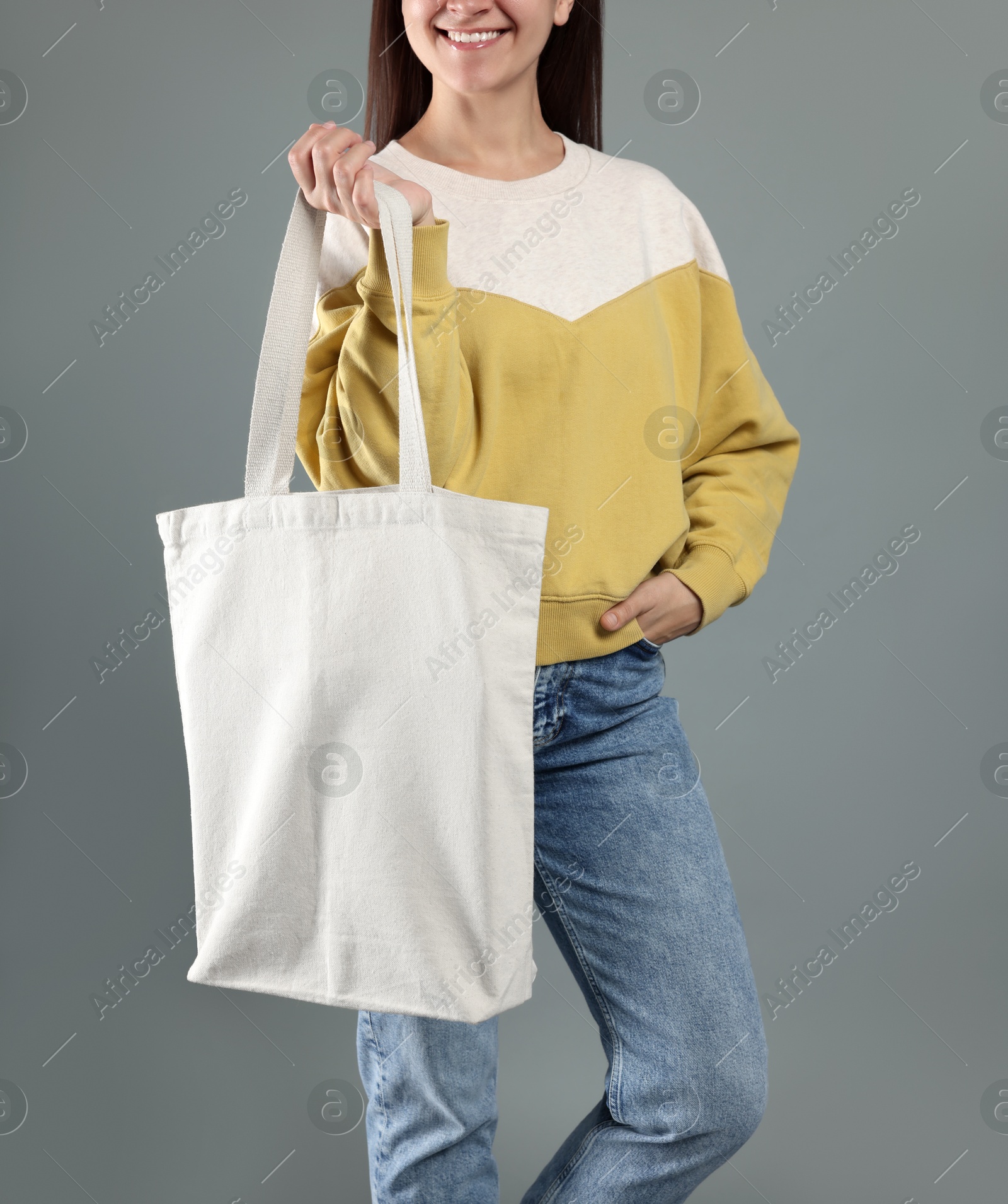 Photo of Woman with blank shopper bag on grey background, closeup. Mockup for design