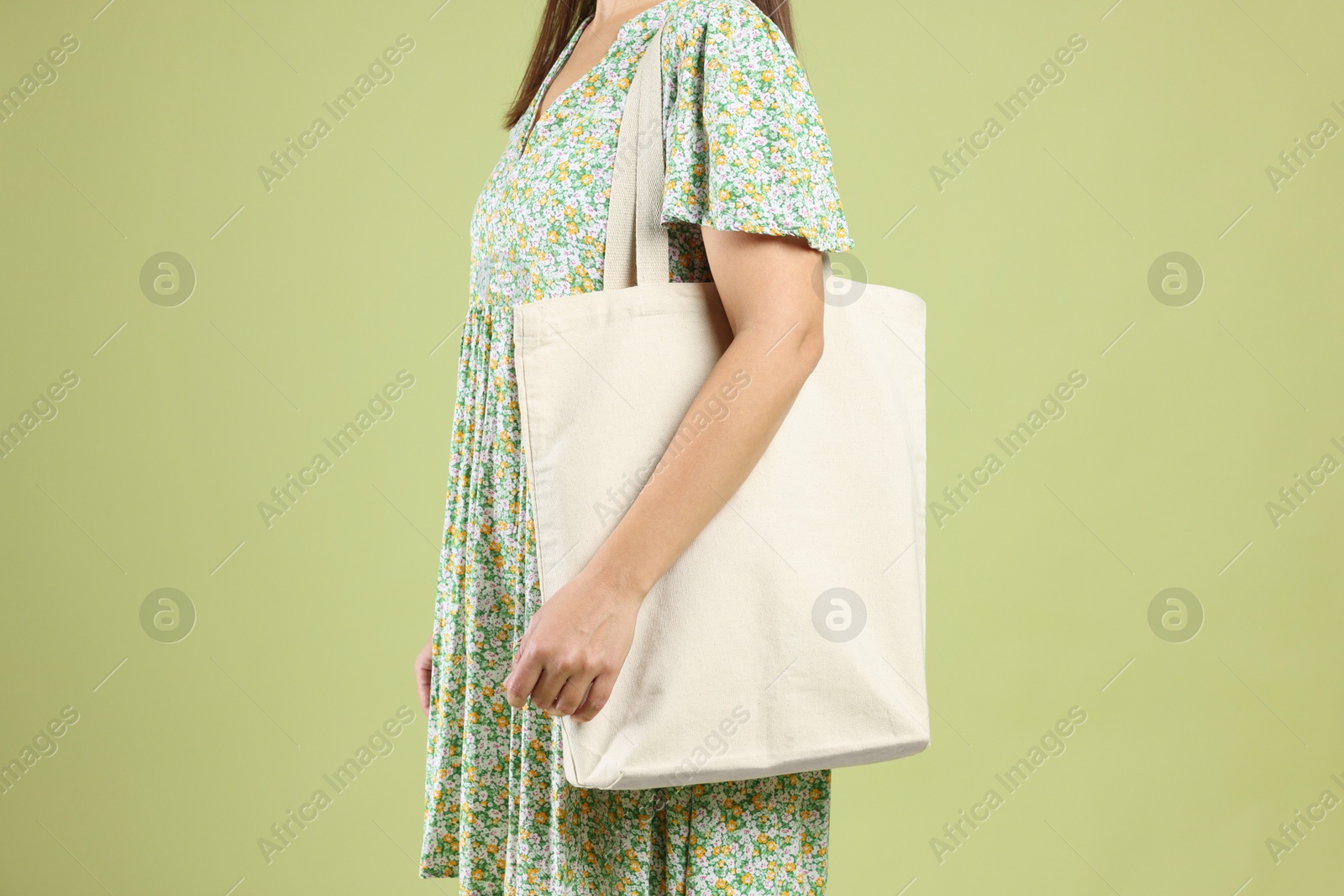 Photo of Woman with blank shopper bag on color background, closeup. Mockup for design