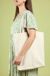 Woman with blank shopper bag on color background, closeup. Mockup for design