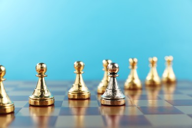 Photo of Silver pawn in front of golden ones on chessboard, closeup. Competition concept