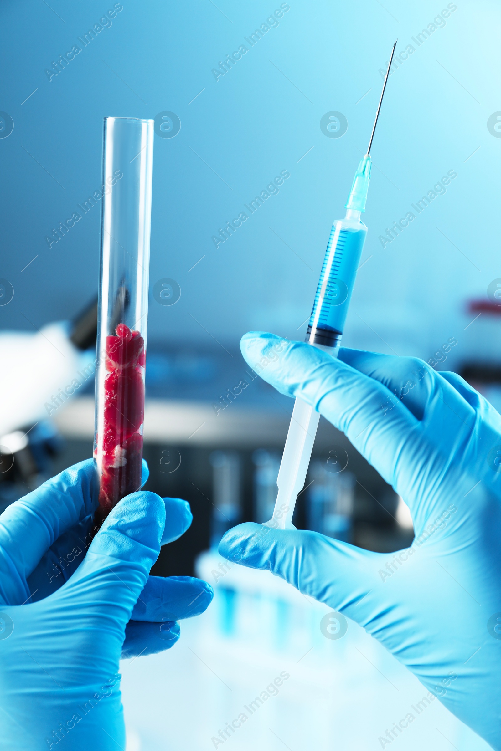 Photo of GMO concept. Scientist with syringe and piece of meat in test tube at laboratory, closeup