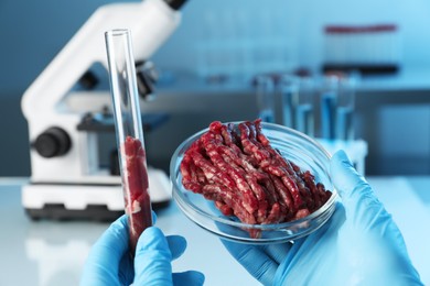 Photo of GMO concept. Scientist with raw meat in glassware at laboratory, closeup