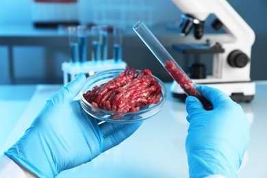 Photo of GMO concept. Scientist with raw meat in glassware at laboratory, closeup