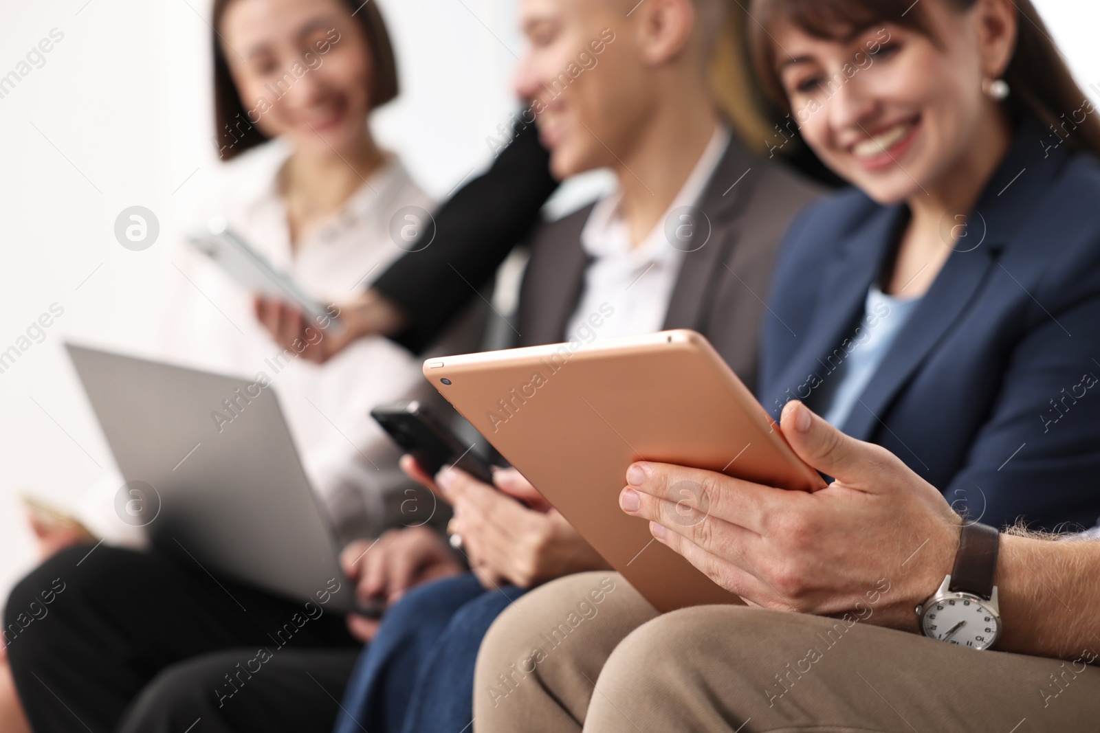 Photo of Group of people using different gadgets indoors, selective focus. Modern technology