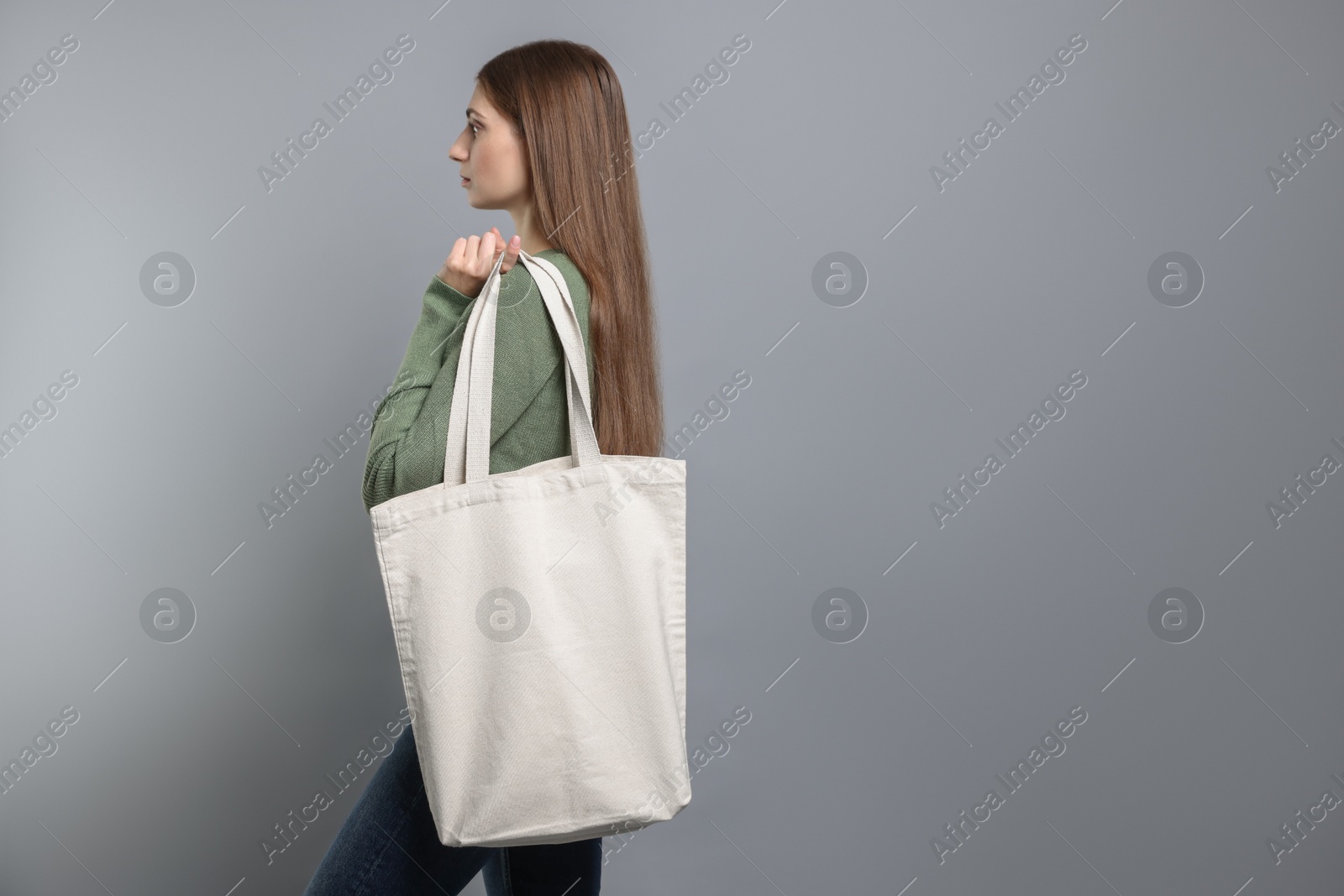 Photo of Woman with blank shopper bag on grey background. Mockup for design