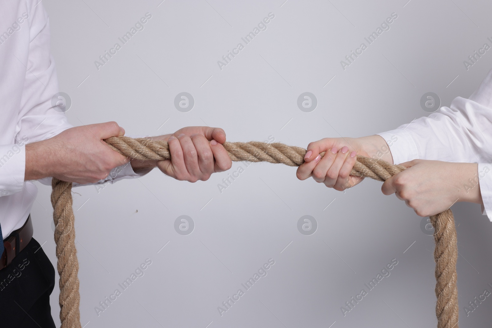 Photo of Competition concept. Businesspeople pulling rope on grey background, closeup